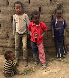 Ethiopian children watch the immunization volunteers.